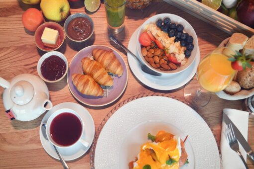 Genussfrühstück Blick von oben auf einen reich gedeckten Frühstückstisch.