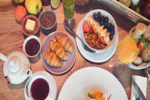 Genussfrühstück Blick von oben auf einen reich gedeckten Frühstückstisch.