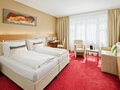 Premium Room with twin bed, TV, seating area and coffee table| Hotel Anatol in Vienna