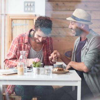 Gay Cafés und Bars | © Shutterstock Zwei Männer halten Händchen in einem Café | © Shutterstock
