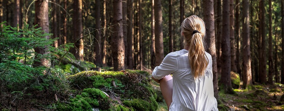 Frau mit Blick auf den ruhigen Wald