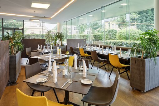 Restaurant | Hotel Congress Innsbruck Restaurant with laid table and outside view | Hotel Congress Innsbruck