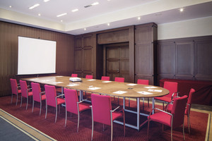 Centaurus seminar room with round table, screen and elegant, dark wooden walls | Hotel Ljubljana in Slovenia