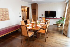 Meeting room Suite 905 with a small, seated table, a folding screen and white walls | Hotel Ljubljana in Slovenia