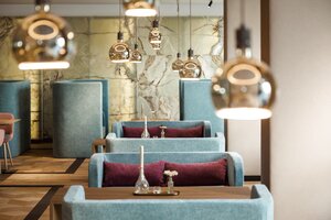 Sicht auf Tische im Restaurant-/Lounge-Bereich im Hotel Maximilian