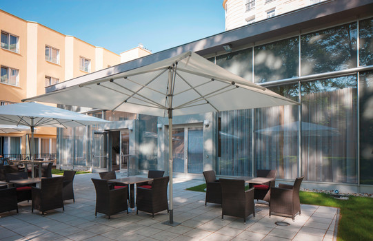 Terrasse mit Sitzgelegenheiten und Schirm | Parkhotel Schönbrunn in Wien