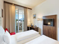 Innenansicht Superior Zimmer mit Blick auf Bett und Balkon| Hotel Salzburg Messe