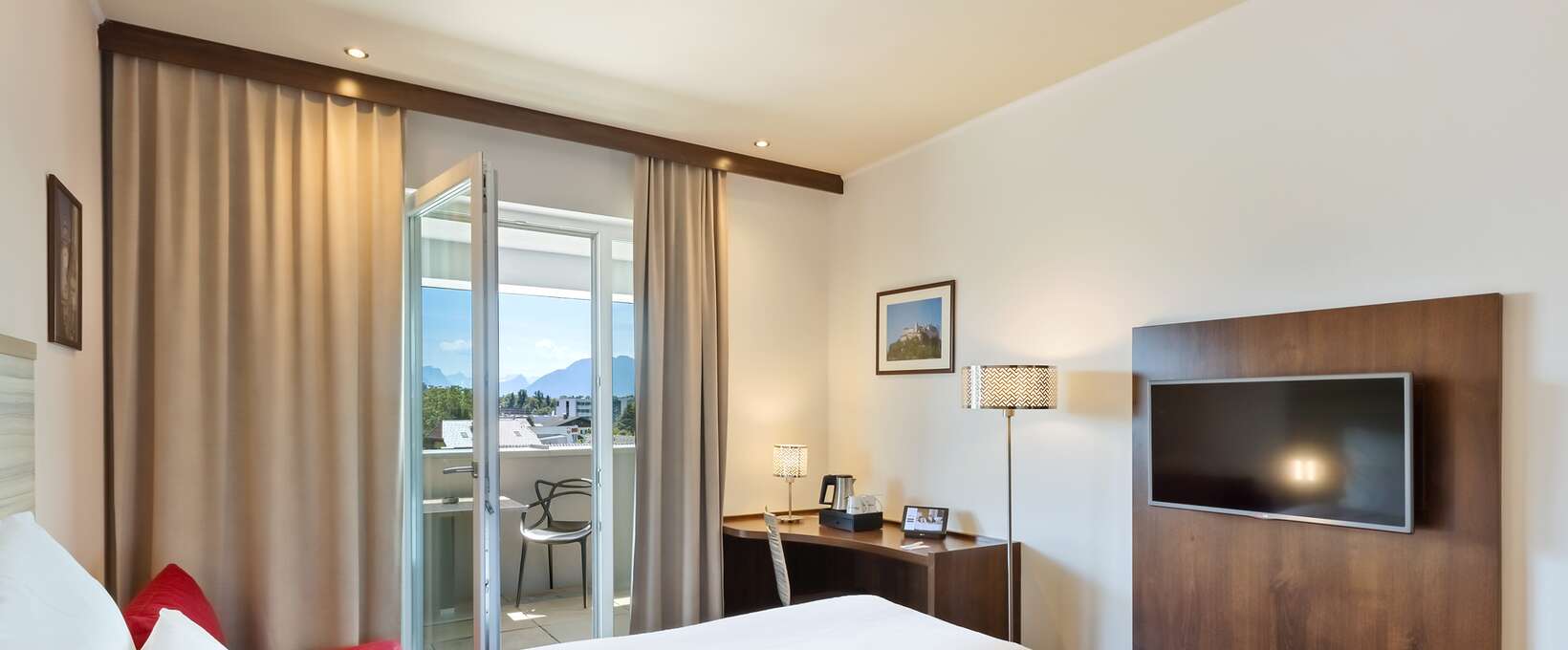 Interior view of superior room with view of bed and balcony | Hotel Salzburg Messe