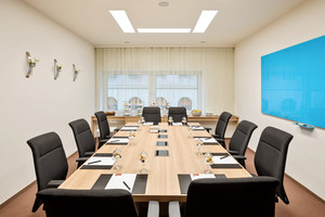 Schicker Seminarraum "Maurice" mit großem Konferenztisch, zehn Lederstühlen und Whiteboard | Austria Trend Hotel Savoyen