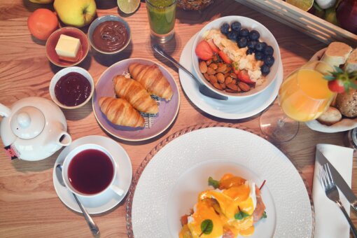 Blick von oben auf einen reich gedeckten Frühstückstisch.