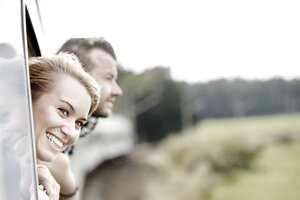 Go Green Package - part of the sustainability initiative of Austria Trend Hotels shows a lady leaning out of a train window and smiling.