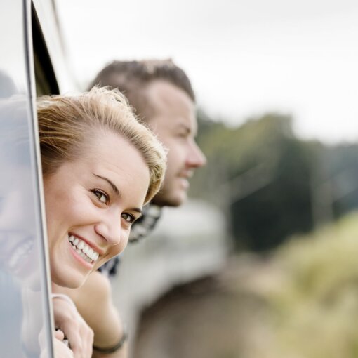 Smiling lady promotes “Go green”  Go Green Package - part of the sustainability initiative of Austria Trend Hotels shows a lady leaning out of a train window and smiling.